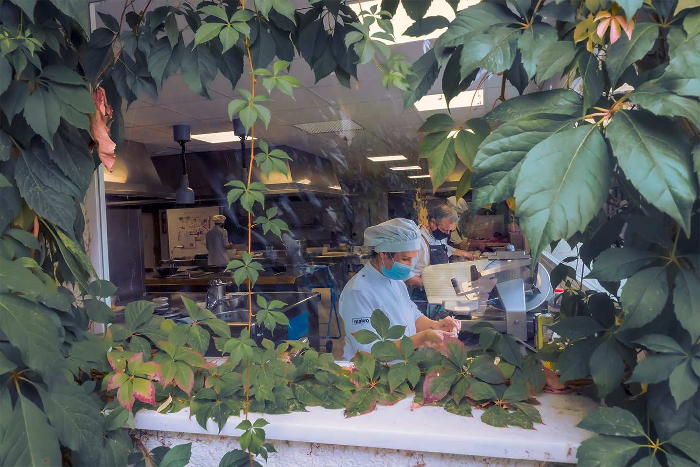 Imagen de un cocinero trabajando detrás de un jardín vertical.